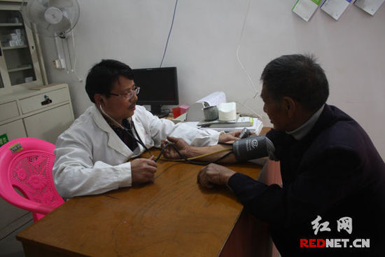 李石清正在給71歲的村民凡冬林量血壓。